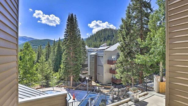 A view from a balcony overlooking a swimming pool, surrounded by trees and a mountain. - Cozy Ski-in/out Winter Park Studio w/ Hot Tubs! (Winter Park)
