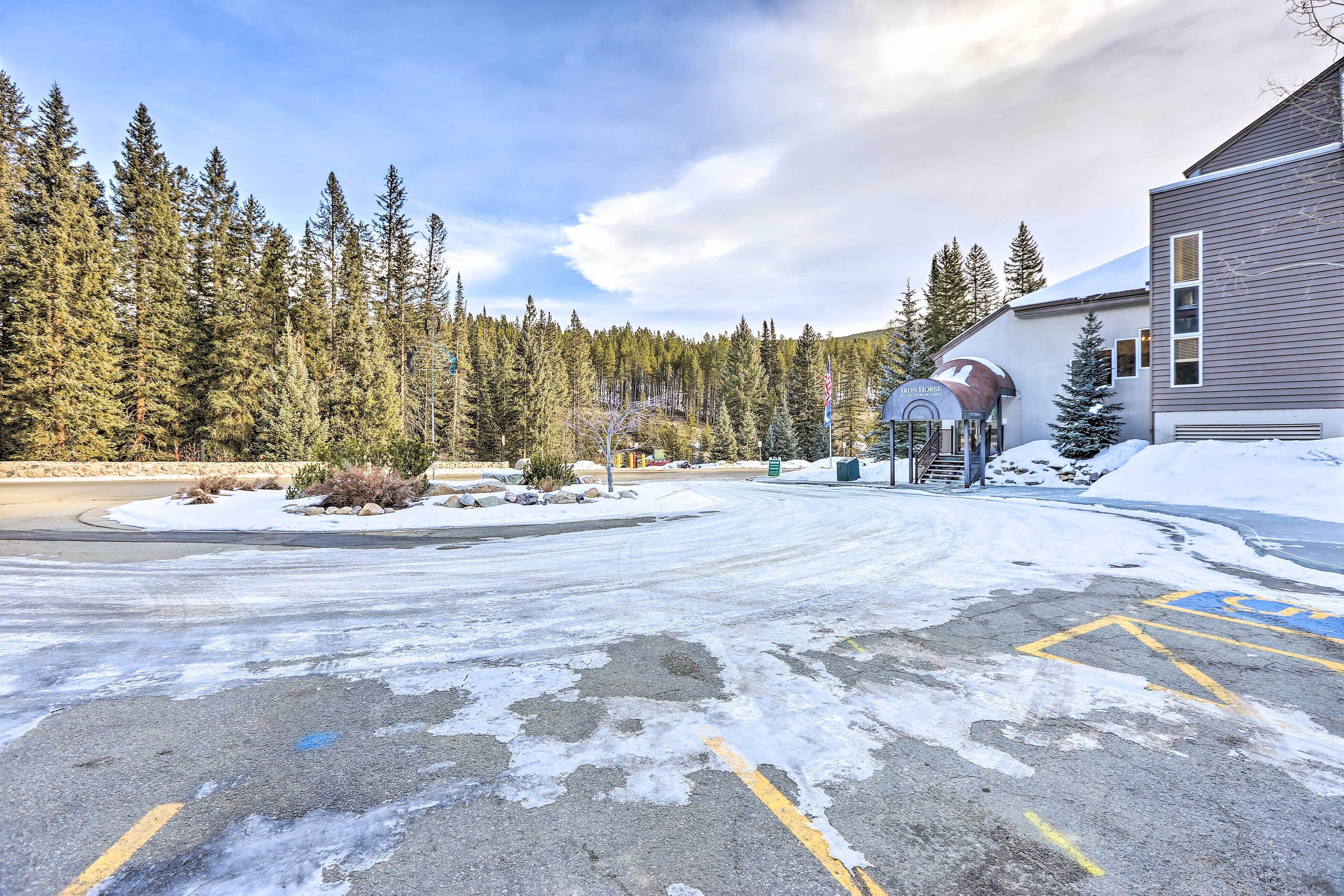 Un estacionamiento con suelo cubierto de nieve y un edificio con un letrero que dice "The Horse Inn".