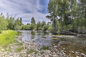 A river with clear water, surrounded by rocks and greenery. - Fish, Hike & Ski: Riverfront Granby Cabin! (Granby)