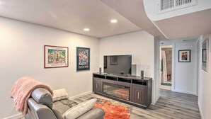 A modern living room with a leather sofa, entertainment unit, and artwork on the walls.