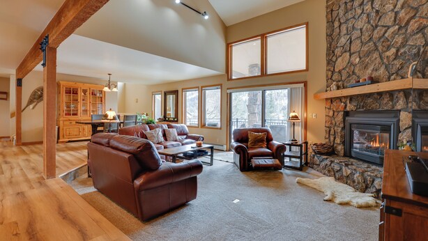 A spacious living room with a fireplace, leather sofas, and a stone accent wall. - Deck + Mtn View: Keystone Townhome Near Resort! (Keystone)