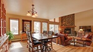 A spacious living room with a fireplace, a dining area with a wooden table and chairs, and a cozy seating area with a leather couch. - Deck + Mtn View: Keystone Townhome Near Resort! (Keystone)