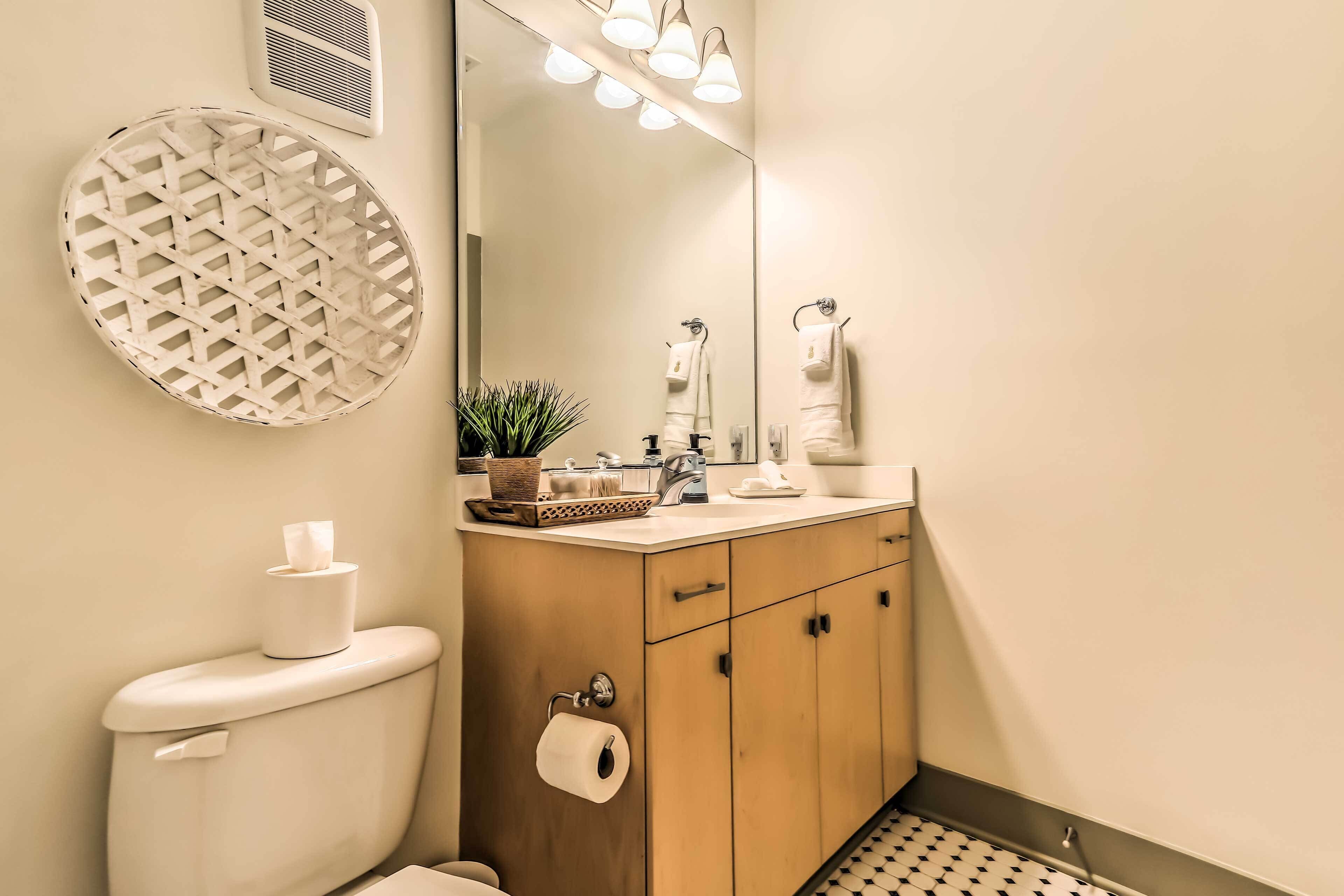 Een badkamer met toilet, wastafel, spiegel en handdoekhouder.