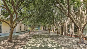 Uma trilha arborizada com edifícios de ambos os lados.