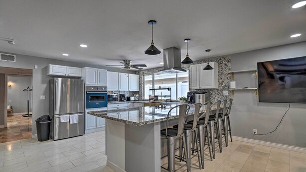 A modern kitchen with a central island, stainless steel appliances, and pendant lighting. - Home w/ Private Pool - Near Las Vegas Strip! (Las Vegas)