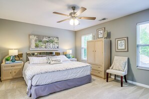 A bedroom with a bed, nightstands, a chair, a ceiling fan, and a large window. - Home Sweet Home' w/ Private Pool + Patio! (Knoxville)