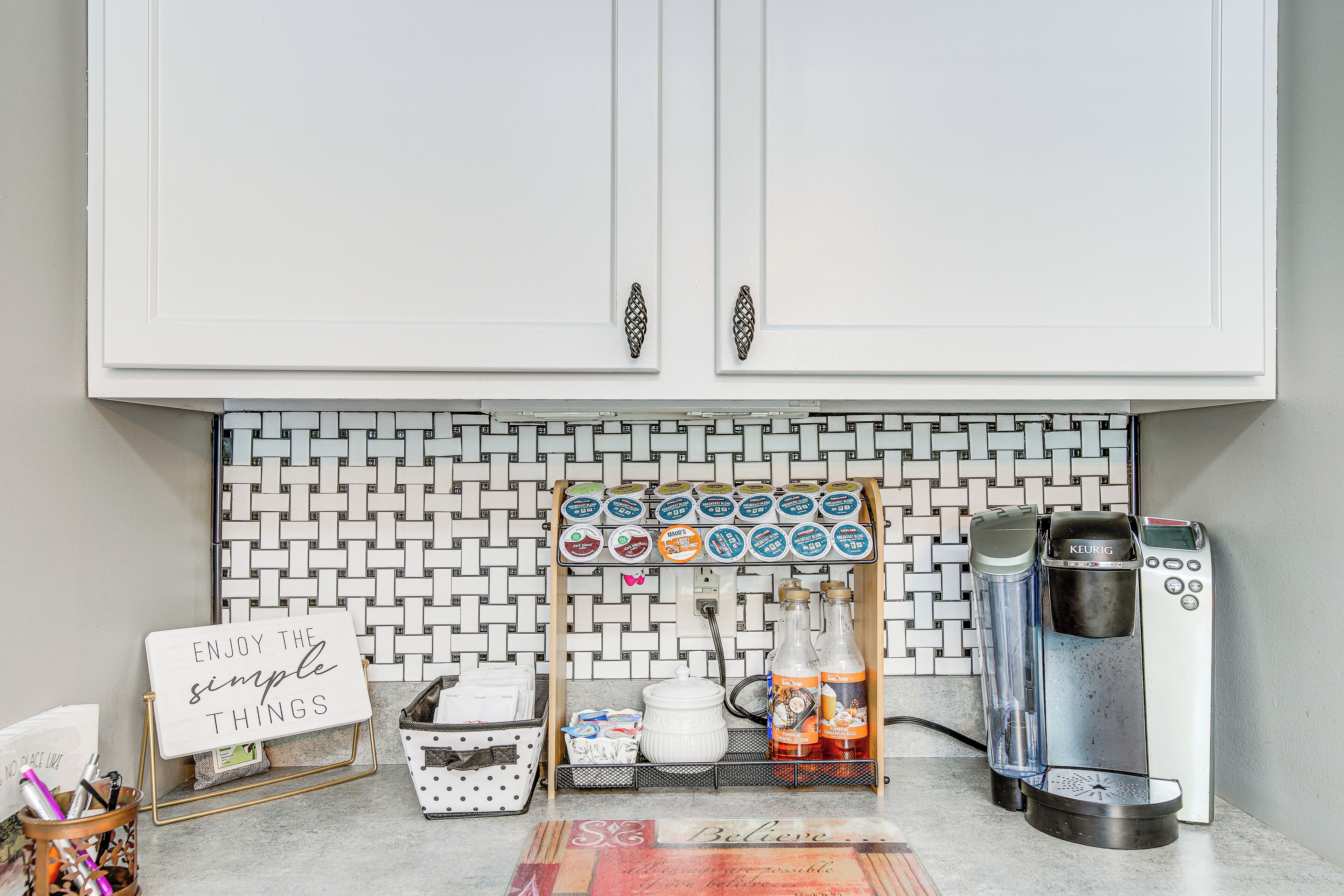 A kitchenette with a coffee machine, a water dispenser, and a coffee pod holder.