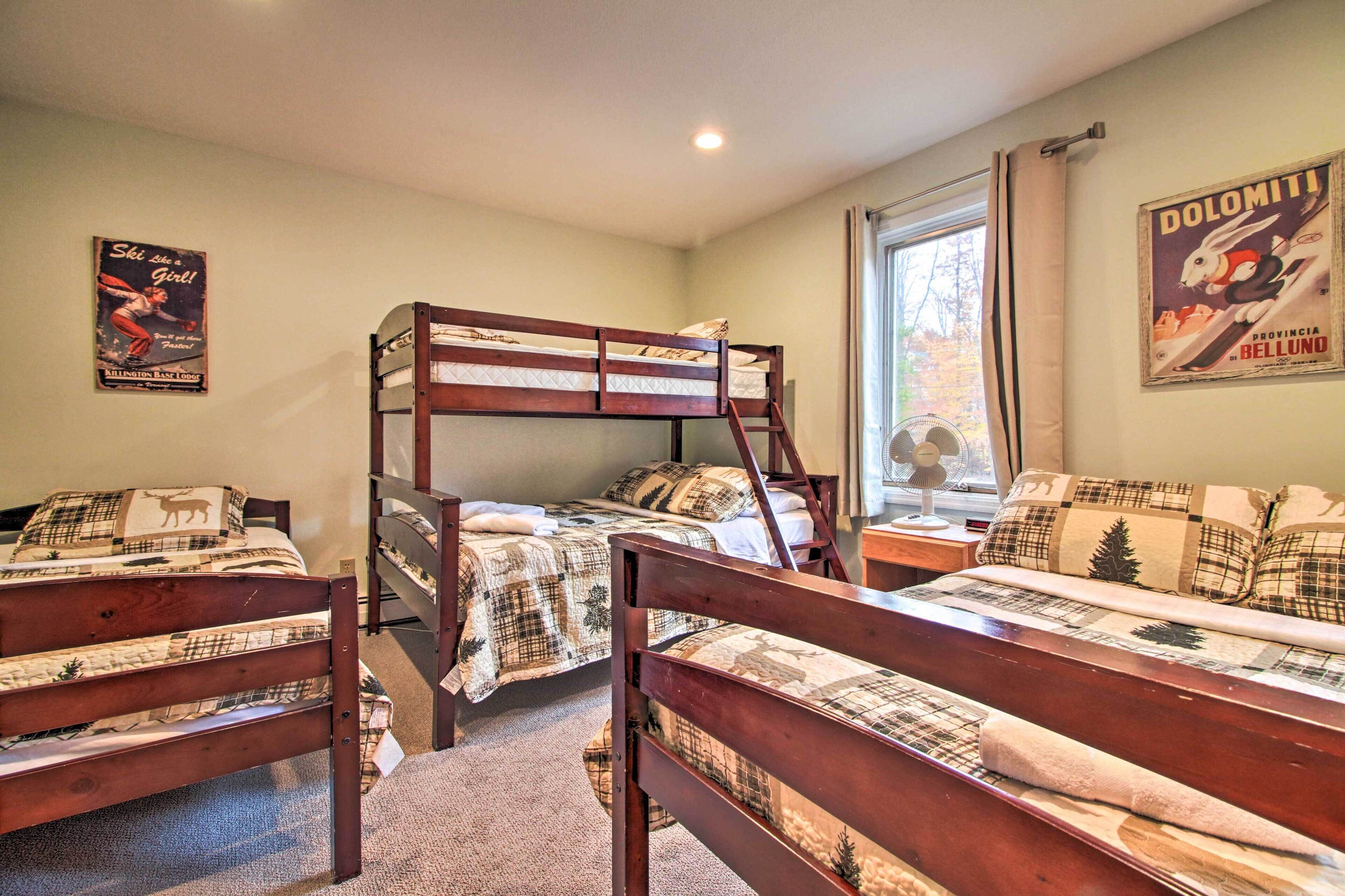 A dormitory room with bunk beds, a window with curtains, and a poster on the wall.