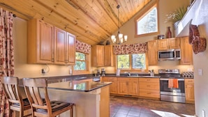 A spacious kitchen with wooden cabinets, a central island, and modern appliances. - Luxury 4 BR Cabin: 2 King Suites on Shuttle Route (Winter Park)