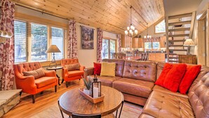 A cozy living room with a wooden ceiling, leather sofas, and a dining area in the background. - Luxury 4 BR Cabin: 2 King Suites on Shuttle Route (Winter Park)