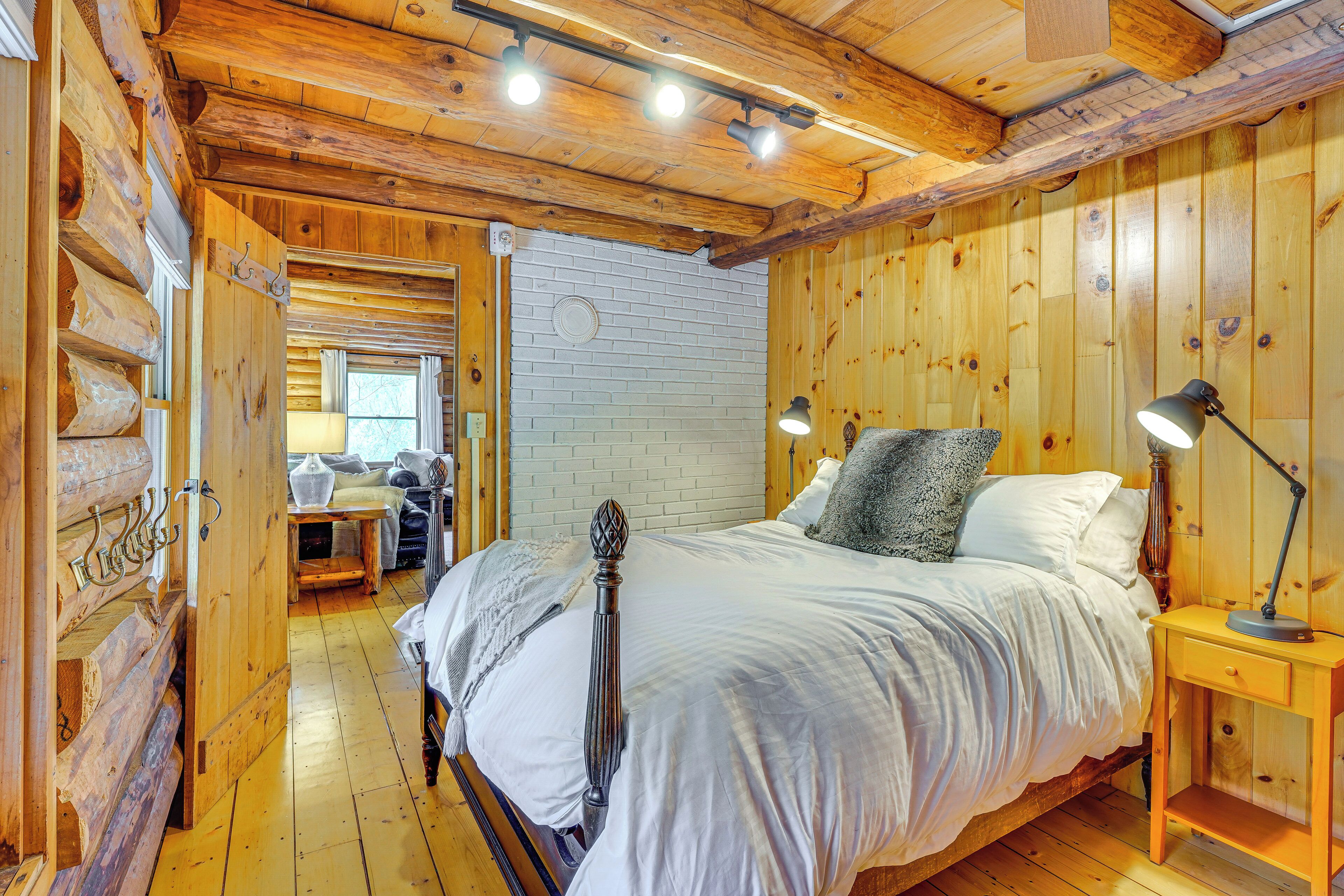 Ein Schlafzimmer im Chalet-Stil mit einem Bett, Nachttischlampen und einem Fenster.