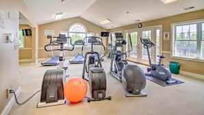 A gym with treadmills, elliptical machines, and a stationary bike. - Renovated Ski-in/ski-out Peru Condo at Bromley Mtn (Peru)