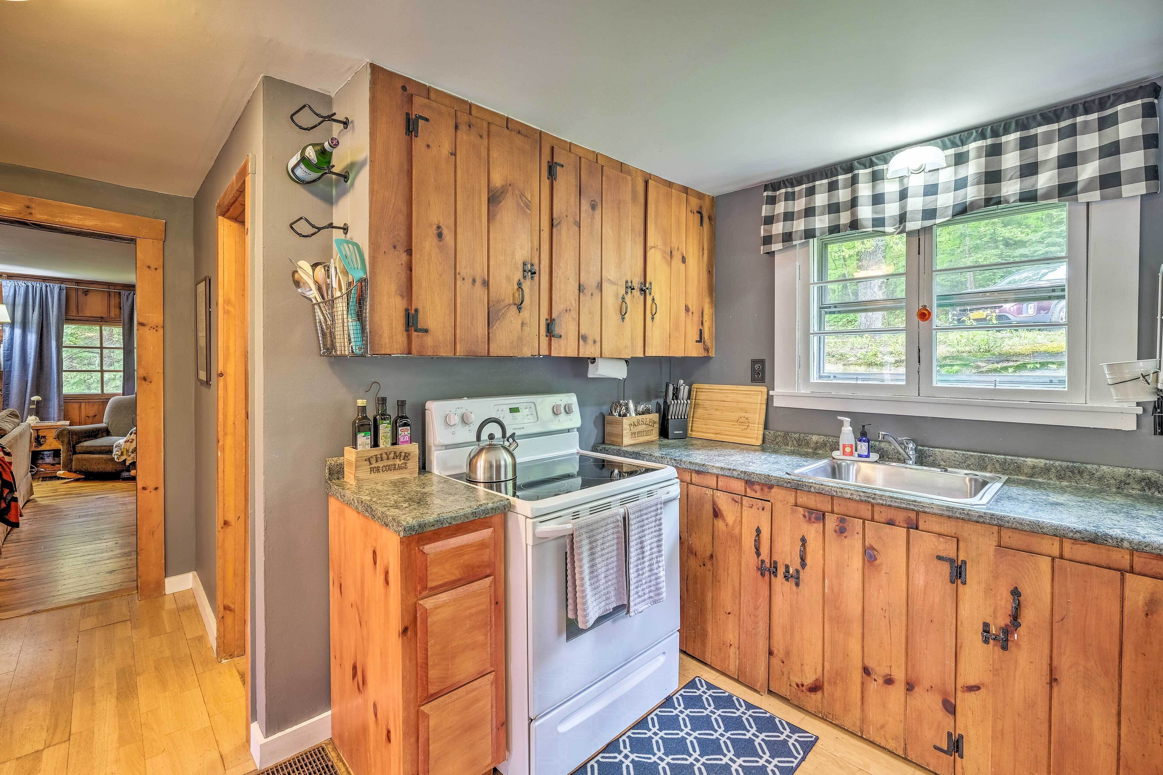 A kitchen with wooden cabinets, a stove, and a sink.