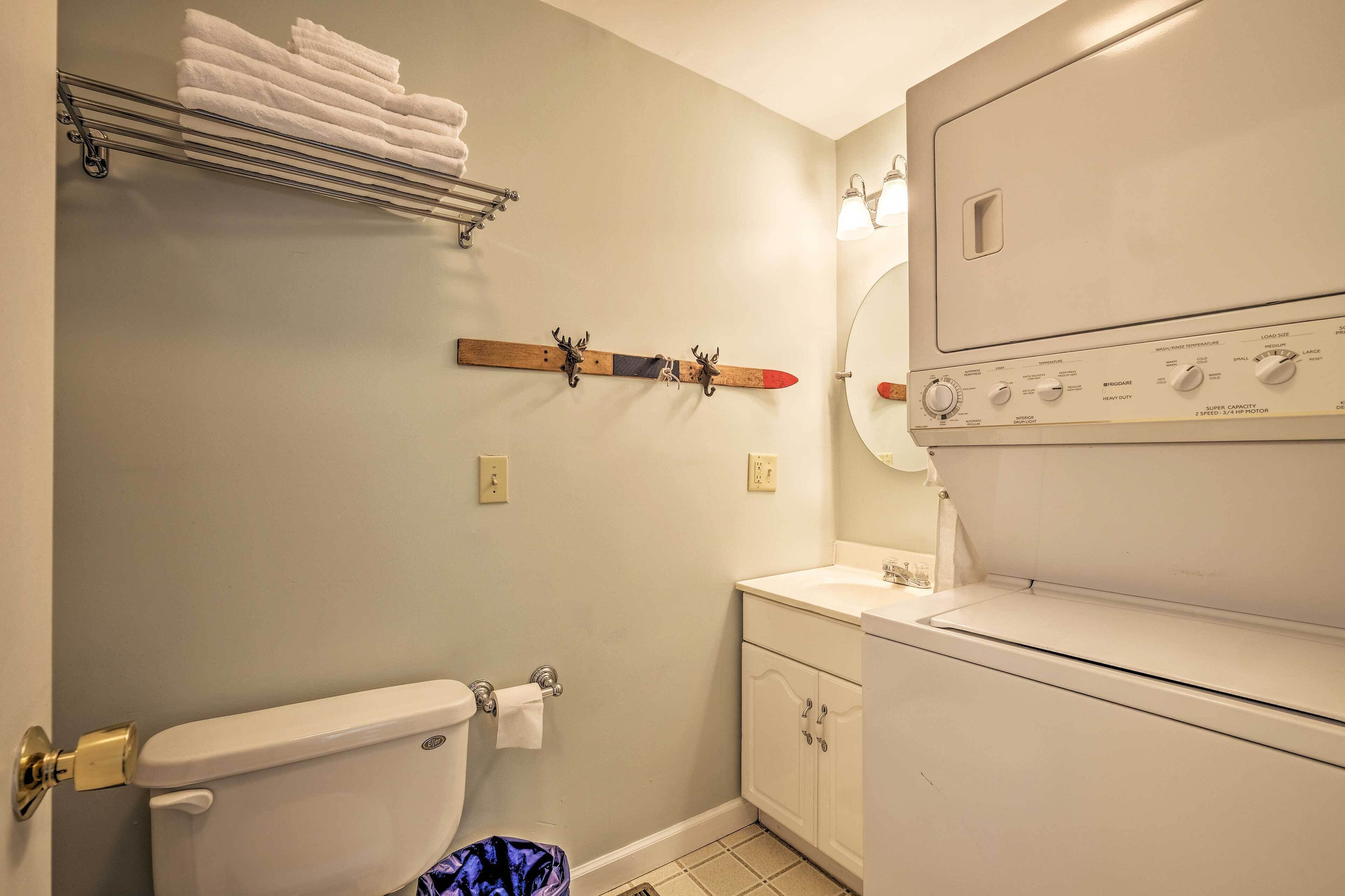 A bathroom with a toilet, a sink, a towel rack, and a wall-mounted heater.