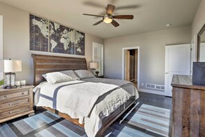 Relax in a spacious bedroom with a large bed, ceiling fan, and world map artwork.
