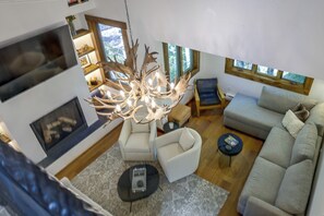A modern living room with a fireplace, a chandelier, and a sofa. - Newly Renovated Vail Home - Walk to Booth Falls Tr (Vail)