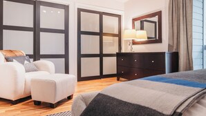 Ein Schlafzimmer mit Bett, Sofa, Kommode und Spiegel.
