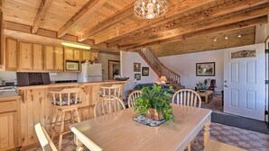 A wooden interior with a dining table, chairs, a kitchen area, and a staircase. - Questa Home w/ Views - 13 Mi to Red River Skiing! (Questa)