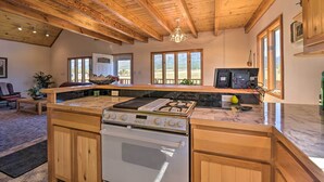 A kitchen with wooden cabinets, a gas stove, and a microwave. - Questa Home w/ Views - 13 Mi to Red River Skiing! (Questa)