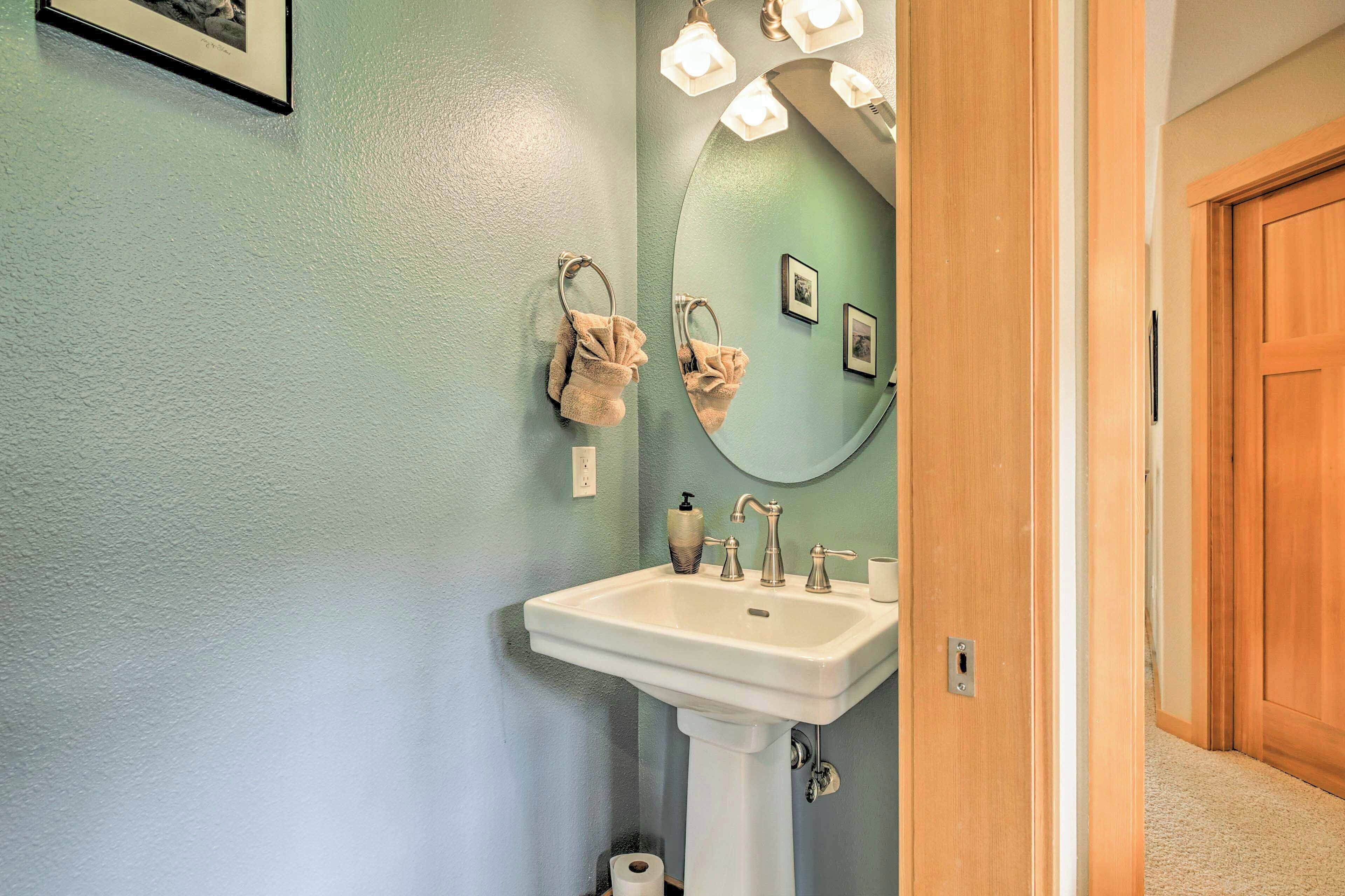 A bathroom with a white sink, a mirror, and a towel rack.