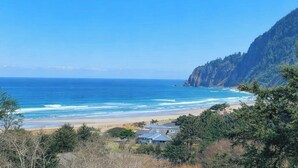 Un paisaje costero con playa, océano y una montaña.