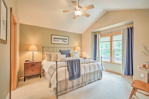 A bedroom with a bed, two bedside tables, a ceiling fan, a window with curtains, and a small table with a lamp. - Spacious Family Townhome: Walk to Beach & Downtown (Manzanita)