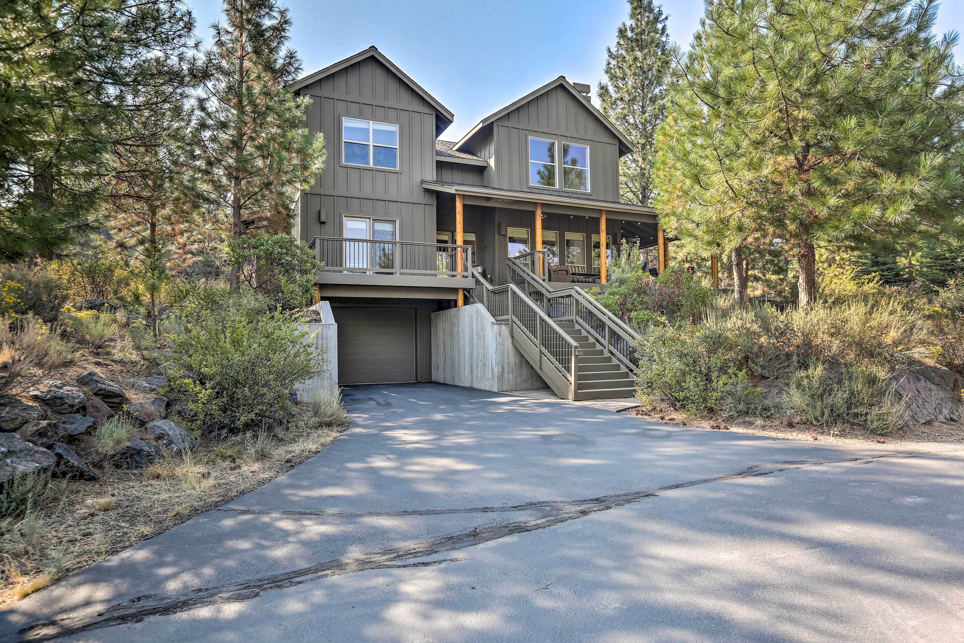 A two-story house with a covered driveway and a staircase leading to the entrance.