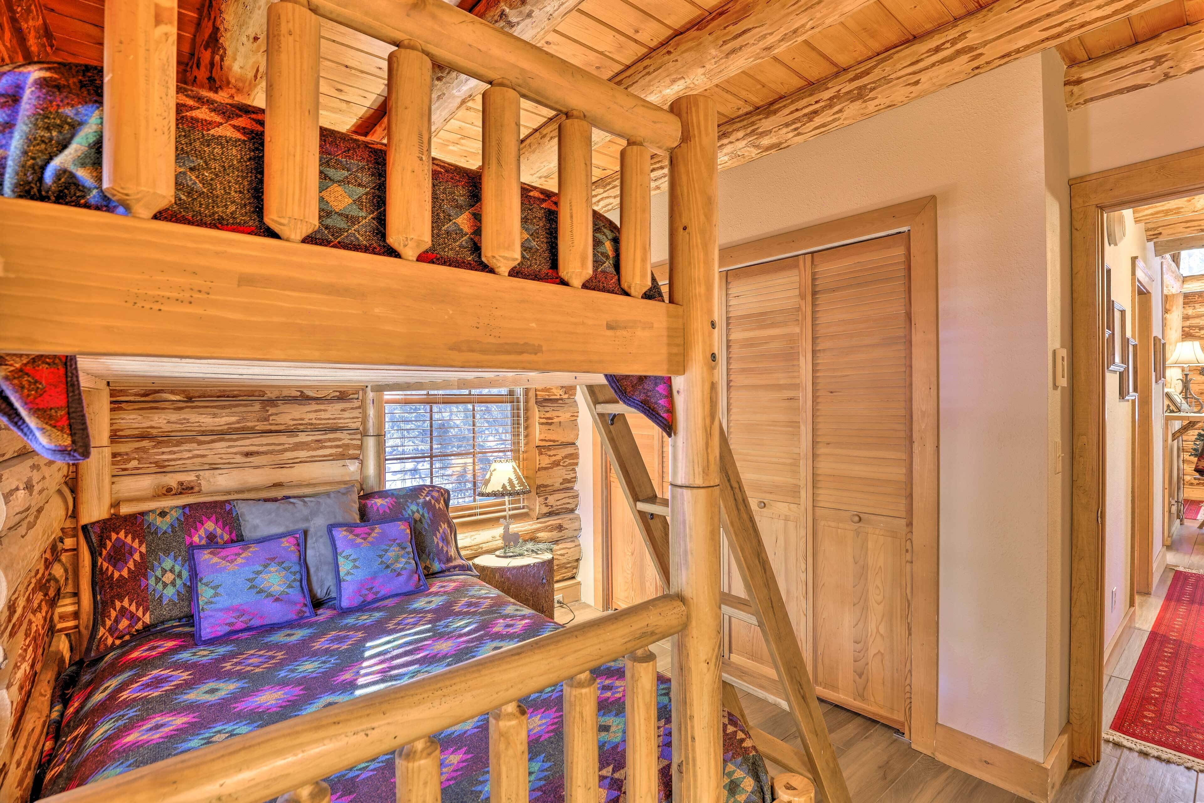L’intérieur d’une cabane en bois comprend un lit superposé, un escalier en bois et un grand placard.