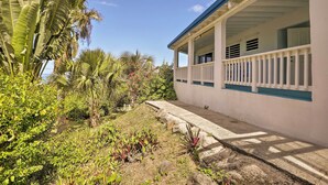 A house with a covered porch, surrounded by tropical vegetation. - St Croix Home w/ Caribbean Views - 1 Mi to Beach (Kingshill)
