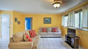 A living room with two sofas, a TV stand, and a ceiling fan. - St Croix Home w/ Caribbean Views - 1 Mi to Beach (Kingshill)