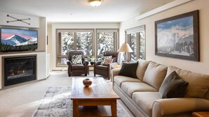 A living room with a fireplace, a sofa, a coffee table, and a TV.