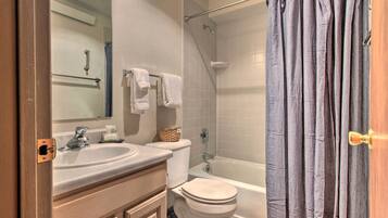 A bathroom with a sink, toilet, and bathtub.