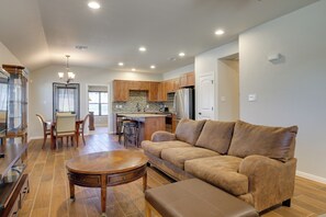 A spacious living room with a brown leather sofa, a wooden coffee table, and a dining area with a wooden table and chairs. - Canyon Lake Home w/ Grill ~ 1 Mi to Boat Ramp (Canyon Lake)