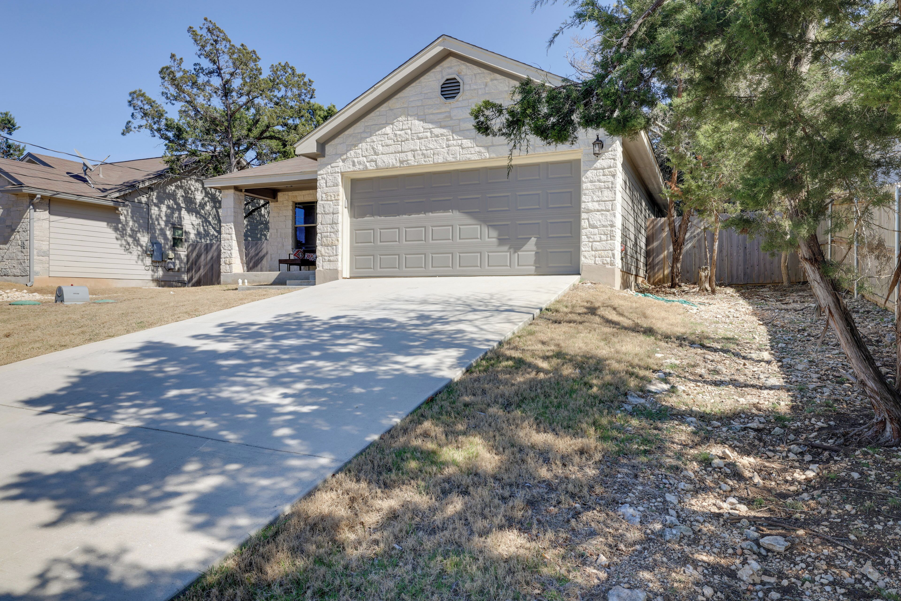 A residential house with a stone facade, a garage, and a driveway leading to the entrance.