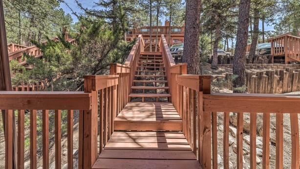 A wooden staircase leading to a cabin surrounded by trees. - Forested Ruidoso Condo w/ Deck & Fireplace! (Ruidoso)