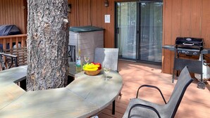 A wooden deck with a table, chairs, a grill, and a tree. - Forested Ruidoso Condo w/ Deck & Fireplace! (Ruidoso)