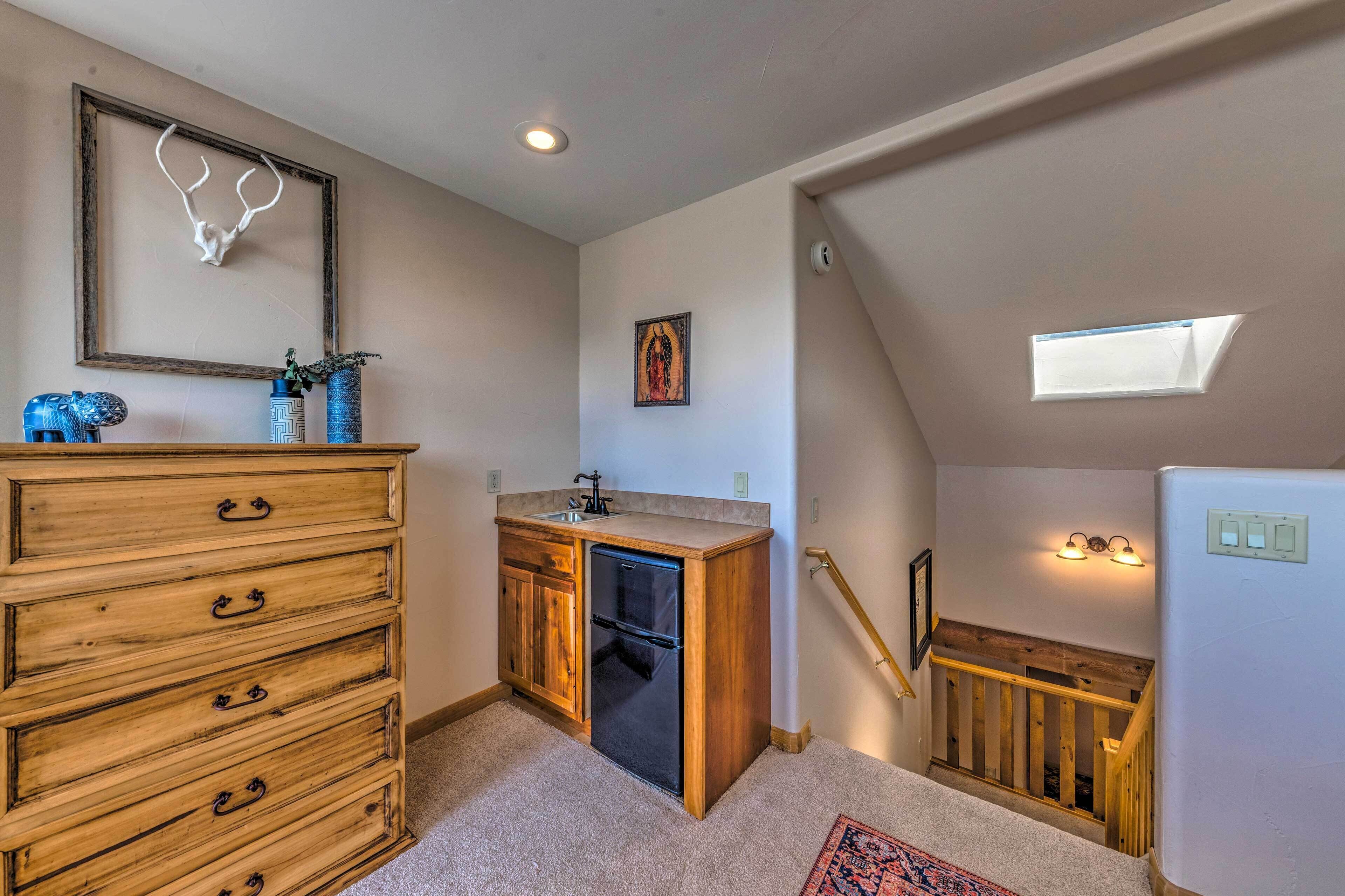 A kitchen with wooden cabinetry, a built-in refrigerator, and a small sink.