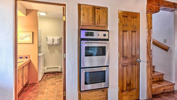 A kitchen with a built-in oven and a wooden door. - El Prado Townhome w/ View of Taos Mountains! (El Prado)