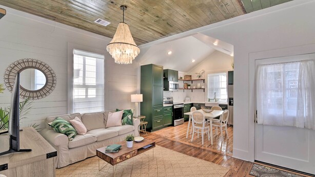 A spacious living room with a sofa, coffee table, and a dining area with chairs. - Near Beach & Strand: Bright Cottage in Galveston (Galveston)