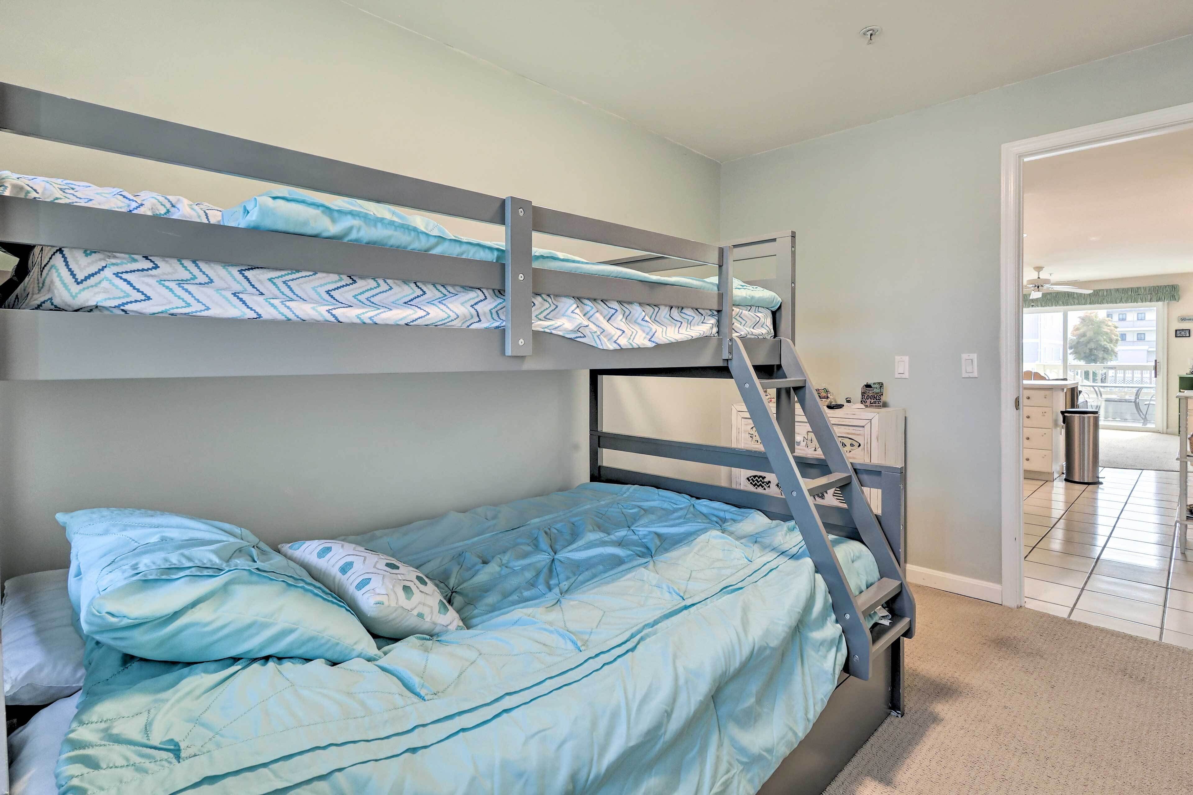 A bunk bed with a ladder, a patterned bedspread, and pillows.