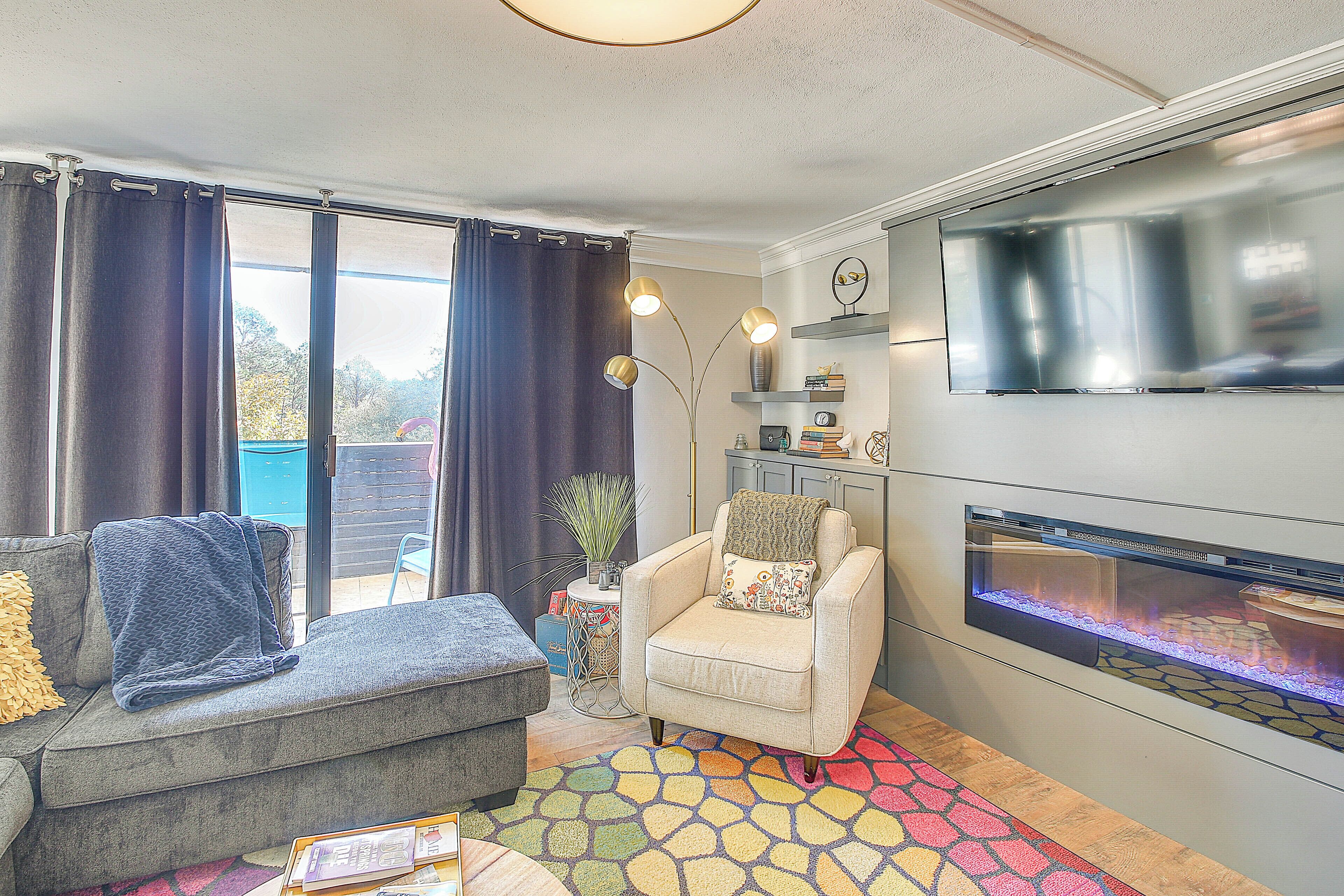 A living room with a sofa, armchair, and a fireplace.