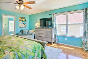A bedroom with a bed, dresser, TV, and large window with curtains. - South Padre Home w/ Pool & Hot Tub: Walk to Beach! (South Padre Island)