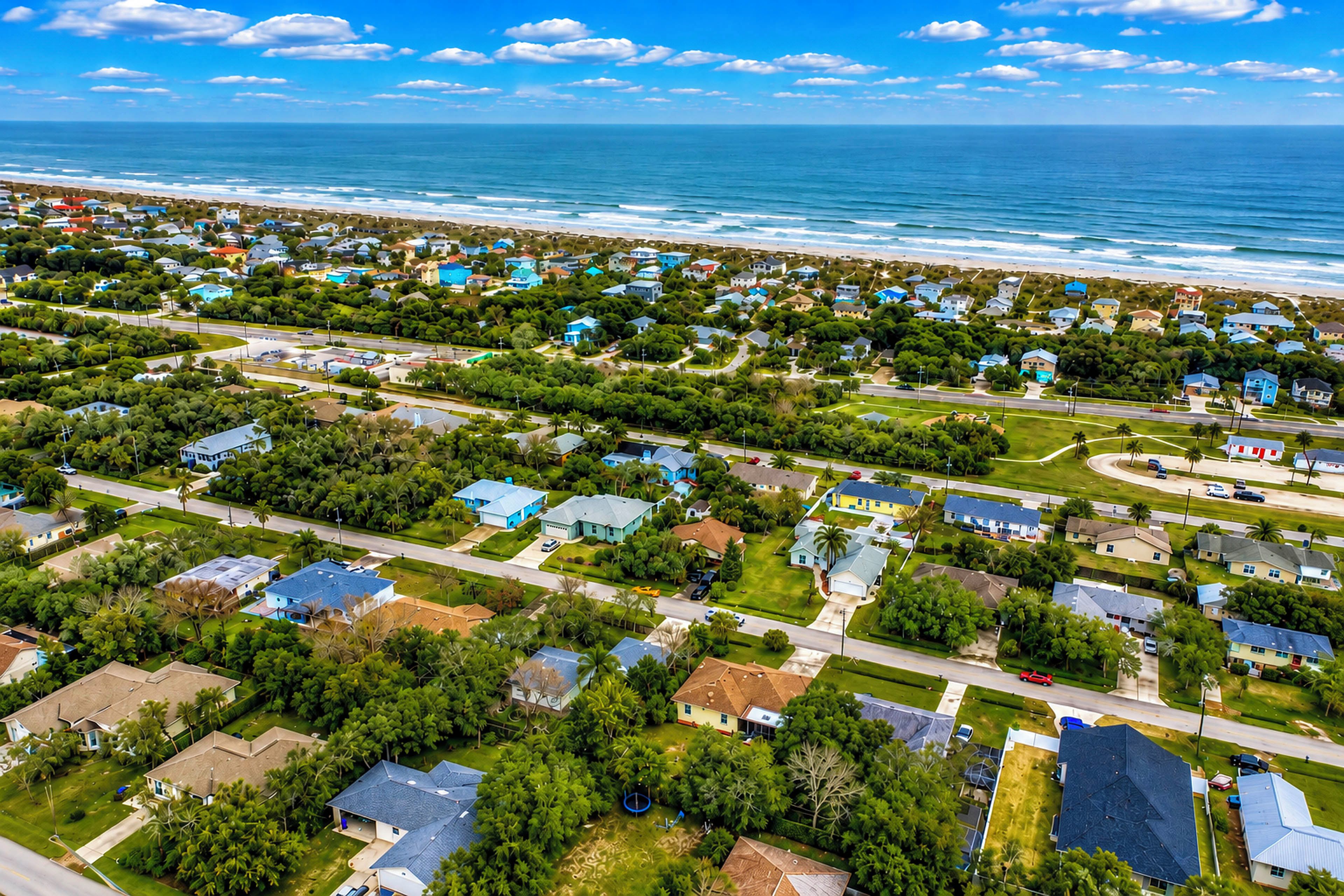 A coastal residential area with houses, roads, and a beach.