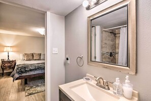 A bathroom with a sink, mirror, and toiletries.