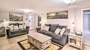 A modern living room with two grey sofas, a wooden coffee table, and a side table with a lamp. - Walkable Galveston Apartment w/ Hot Tub Access (Galveston)