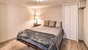 A bedroom with a bed, a nightstand, a lamp, and a closet. - Walkable Galveston Apartment w/ Hot Tub Access (Galveston)
