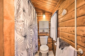 A wooden cabin bathroom with a toilet, a shelf above the toilet, and a towel rack. - Waterfront Sekiu Escape - 9 Mi to Neah Bay! (Sekiu)
