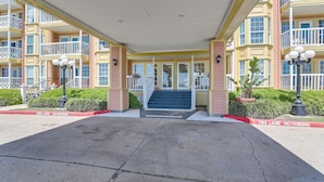 A hotel entrance with a covered walkway, a staircase leading to the entrance, and a fire lane on either side.