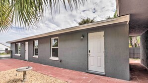 A modern building with a flat roof, a white door, and windows. - Ideally Located West Palm Beach Apartment! (West Palm Beach)