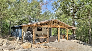 A rustic cabin with a wooden structure, a covered patio, and outdoor seating. - Remodeled Cabin w/ Fire Pit on Norfork Lake! (Elizabeth)